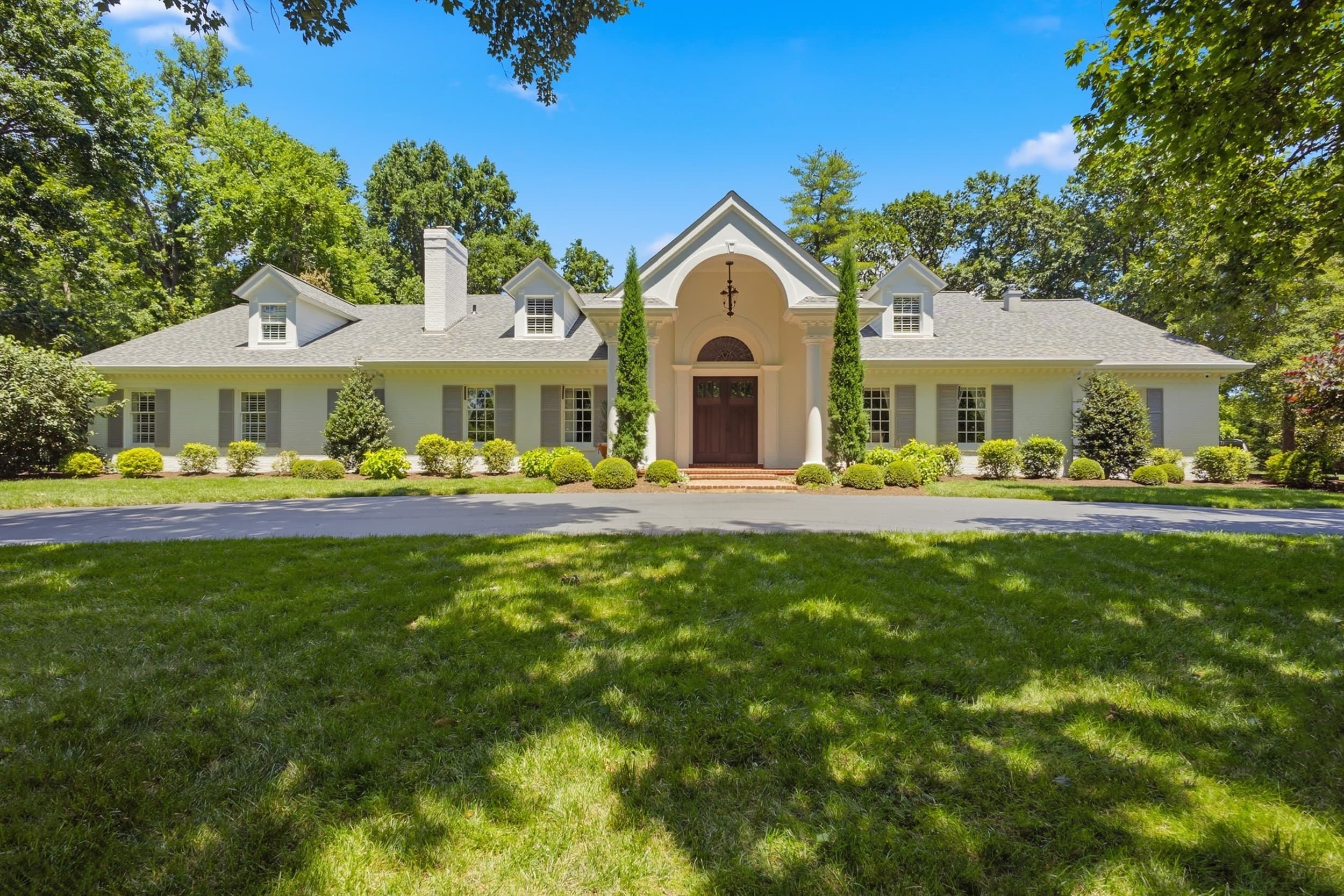 Aerial view of the 11 Rauscher Drive estate, pool, and wooded grounds